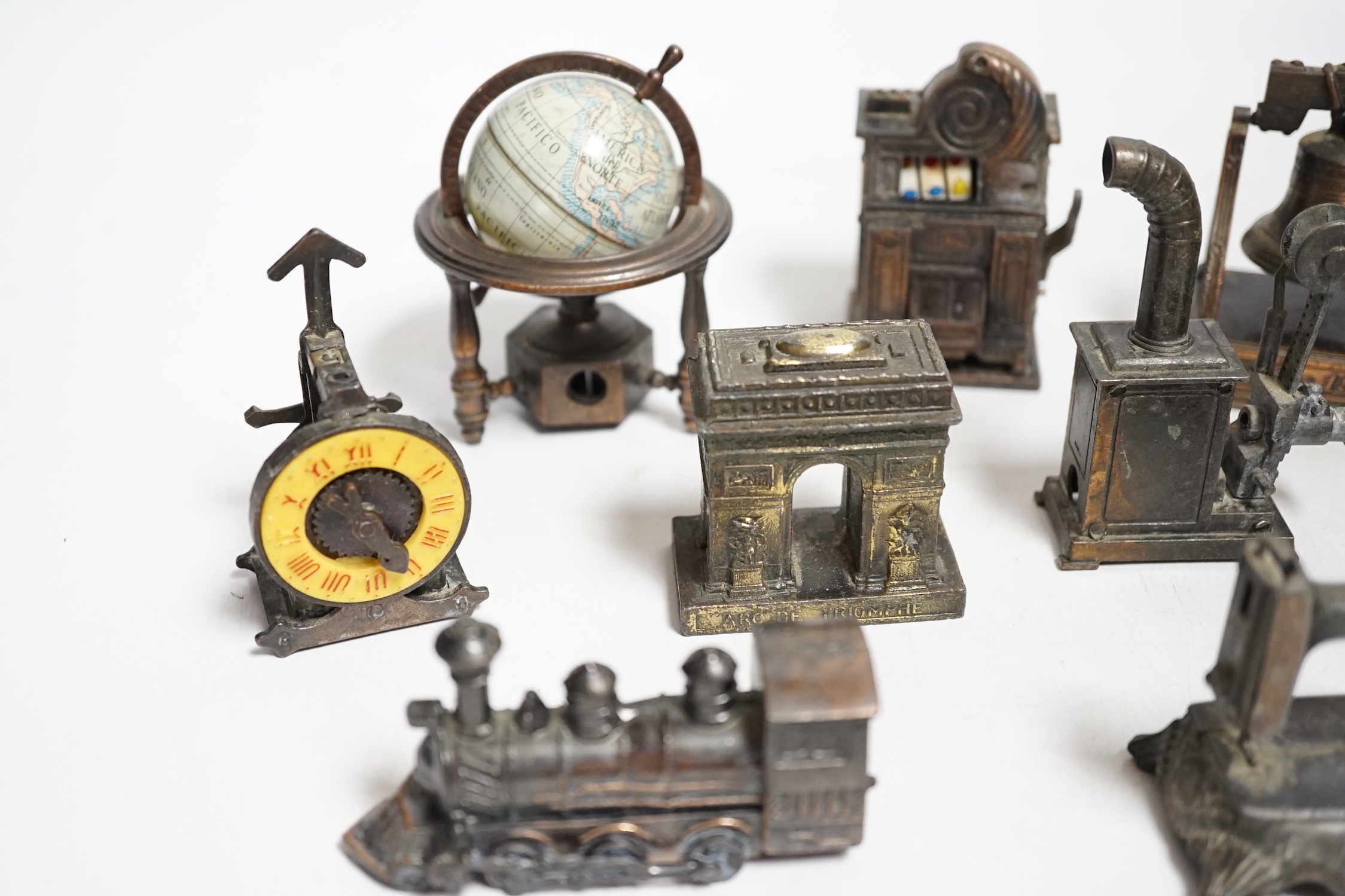 A collection of novelty metal pencil sharpeners and a pair of late Georgian silver plated candlesticks, 20cm